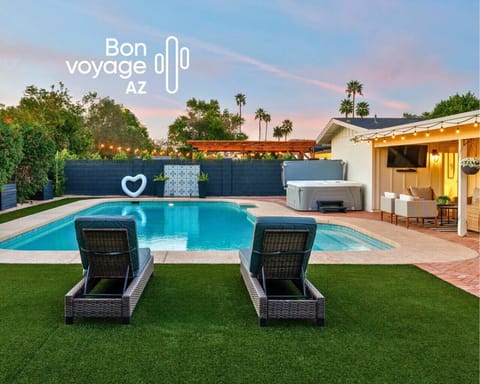 Resort-style backyard featuring a sparkling *heated pool, hot tub, covered patio, outdoor dining area, and expansive lawn perfect for private yoga sessions.