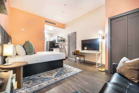 Relax in comfort with a queen bed, smart TV, laptop-friendly desk, and warm lighting—ideal for work or leisure