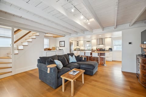 The main living area - with a cozy breakfast nook overlooking the deck, comfy couch with a large smart TV, and gas fireplace. There is seating for 4 at the bar in addition