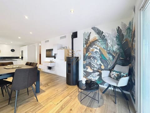 Profitez de cet espace accueillant et moderne, parfait pour se relaxer près du poêle avec une déco tropicale qui inspire l'évasion. La salle à manger encourage les repas conviviaux sous un éclairage doux.