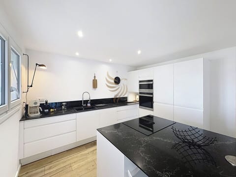 La cuisine spacieuse comprend un îlot central parfait pour cuisiner ensemble. Les espaces de rangement intégrés optimisent l'organisation, rendant cette pièce idéale pour les amateurs de cuisine et de design moderne.