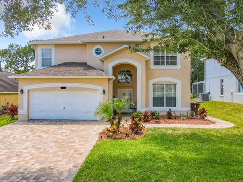 Stunning two-story home in Southern Dunes Golf & Country Club with a private driveway, landscaped yard, and welcoming entryway.