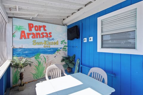 Your private patio features tropical charm with vibrant blue walls, coastal artwork, and comfortable seating for morning coffee or evening relaxation.