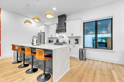 Discover this chic Nashville kitchen, blending modern elegance with cozy charm. With sleek cabinetry, a spacious island, and stylish seating, it's ideal for memorable meals and cocktails—let the culinary adventures begin!