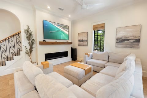 Sink into plush white sofas facing your modern fireplace and large TV—perfect for cozy evenings after exploring nearby attractions.