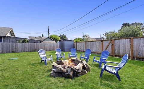 A fully fenced backyard with a cozy fire pit and a spacious seating area, perfect for hosting gatherings.