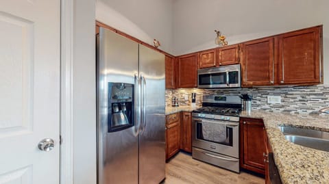 A warm and inviting kitchen with stainless steel appliances, rich wood cabinetry, and a stunning granite countertop—perfect for cooking and gathering! 🍽️✨🏡
