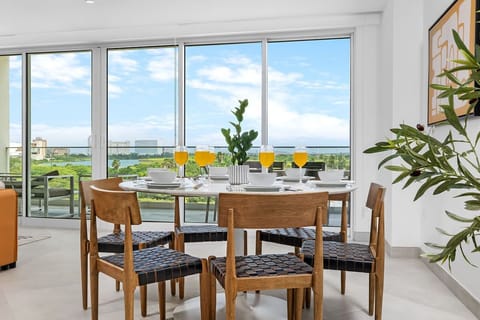 Picture yourself enjoying breakfast at this bright dining table, where floor-to-ceiling windows frame stunning lake views and soft natural light fills the space, making every meal feel special.