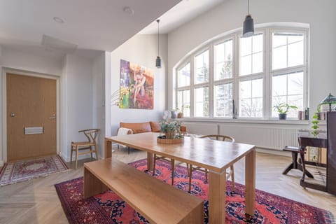 A cosy and stylish top-floor loft, crowned by a living area reaching five metres in height. The loft is furnished with a cognac coffee table and an antique brown piano to match the dignity of the building and the apartment.