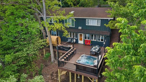 Large deck overlooking the Rock River with a hot tub, dining table, suana, and plenty of seating options.