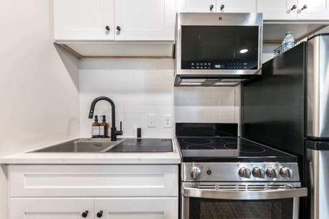 The kitchen includes a 2-in-1 sink dishwasher, as well as a stove/oven, microwave, and refrigerator.