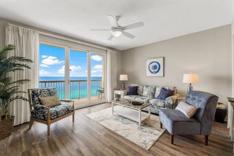 Bright coastal living space with queen sleeper sofa, Smart TV, and expansive views of the Gulf through sliding glass doors to the balcony
