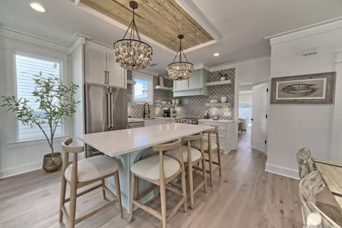 Chic lighting, sleek countertops, and open shelving make this kitchen a true standout.
