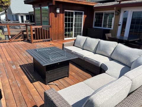 Large outdoor couch on deck with fire propane fire pit