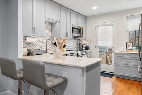 Sleek and functional kitchenette featuring a breakfast bar, full-size appliances