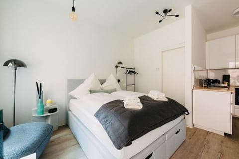 Schlafe wie auf Wolken – unser gemütliches Bett lädt dich zum Entspannen ein.  Weiche Kissen, warme Decken und stilvolles Design sorgen für erholsame Nächte. Starte ausgeruht in den Tag und genieße dein Zuhause auf Zeit in vollen Zügen!