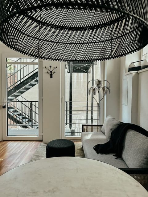 Stilvoll & gemütlich! Die perfekte Balance aus modernem Design und Wohlfühlatmosphäre – mit eleganter Rattanlampe, Designer-Sofa und natürlichem Licht für entspannte Momente. Ein Ort, an dem Stadtflair auf Wohnkomfort trifft!
