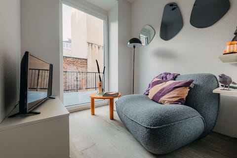 Mach es dir auf dem stylischen Bouclé-Sessel gemütlich, genieße deine Lieblingsserie auf dem Smart-TV oder lass den Blick durch die bodentiefen Fenster schweifen. Perfekt für entspannte Abende mit einem Buch oder einem Glas Wein!