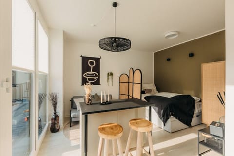 Ein lichtdurchflutetes Studio mit warmen Naturtönen und stilvollen Details. Genieße die harmonische Atmosphäre, entspanne auf dem gemütlichen Sofa oder starte den Tag an der Frühstücksbar. Perfekt für eine erholsame Auszeit in modernem Design.