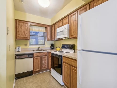 The well-designed kitchen boasts modern appliances including a dishwasher and microwave, perfect for preparing meals during your beach getaway.