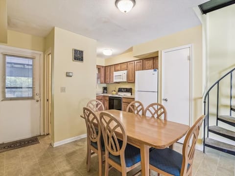 Enter the spacious dining area adjacent to a fully equipped kitchen, offering a family-friendly layout for shared meals and fun gatherings.