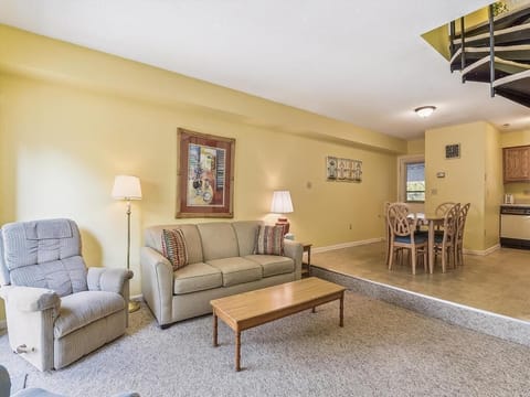 Enjoy quality family time in the inviting living room that offers a seamless flow between the kitchen and dining area, enhanced by warm decor and ample seating.