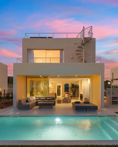 The perfect golden-hour ambiance—where indoor and outdoor living blend seamlessly. Relax by the illuminated pool or lounge on the covered terrace as the sun sets, creating a warm and inviting glow over this stunning retreat.”