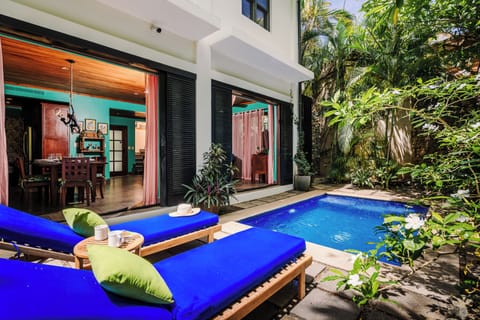 Private pool surrounded by tropical garden at this Playa Langosta vacation rental. Terrace with comfortable loungers, lush landscaping, and outdoor living space. Perfect for sunbathing, relaxation, and coastal luxury inside a gated community.