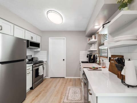 Whip up meals in style in this sleek, modern kitchen! ️✨ Stainless steel appliances, open shelving, and a coffee station make cooking feel effortless and inviting. ☕