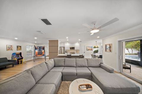 The living room has an electric fireplace, flat screen TV, and multiple seats.