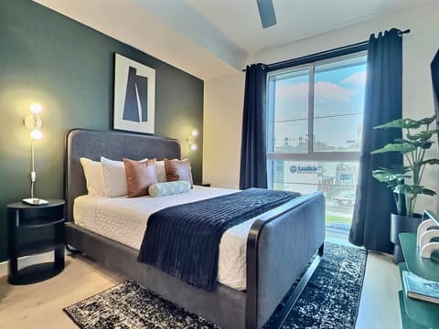 Relax in a cozy bedroom with city views inside a furnished apartment.