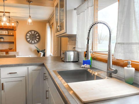A shot of the kitchen sink with a toaster nearby, offering convenience for your meals. In the background, the inviting dining room sets the stage for family gatherings or casual dining, creating a seamless flow between the two spaces.