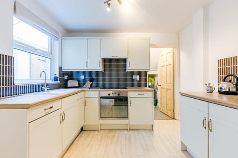 Zareba, St Ives. Lower ground floor: Kitchen two with a fridge/freezer, electric oven, induction hob and utility room with a washing machine