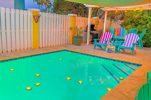 Chill by the inviting pool at this vibrant, coastal retreat, complete with Adirondack chairs, a shaded pergola, BBQ grill, and string lights. Enjoy a colorful, fun-filled outdoor oasis, ideal for relaxing and entertaining after a day at the beach.