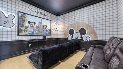 In-home Disney-themed movie room with plush recliners