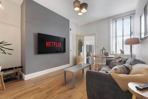 An open-plan living room and dining area benefit from a SMART TV with Netflix, and a comfortable sofa to sit down and relax. 