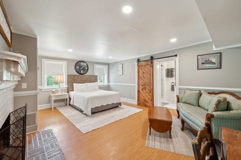 Open bedroom/living space w/ inviting seating area & warm wood floors