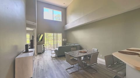 Welcome to a bright and expansive living space! This dramatic, two-story great room features beautiful wood-look flooring, neutral tones, and an open layout that effortlessly connects dining and lounging areas.