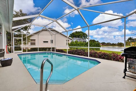 Enjoy a refreshing dip in your screened-in pool with a stunning pond view.