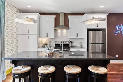 Open floor plan from the kitchen to living room, equipped with comfortable furnishings, plenty of natural light and all the kitchen essentials you would need. Seating at our dining table and the kitchen island.