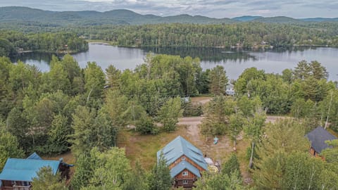 Cabin nestled in trees with lake and rolling hills in the distance