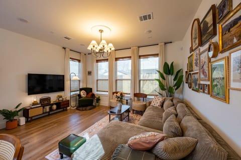 Cozy living room with large windows and vintage charm.