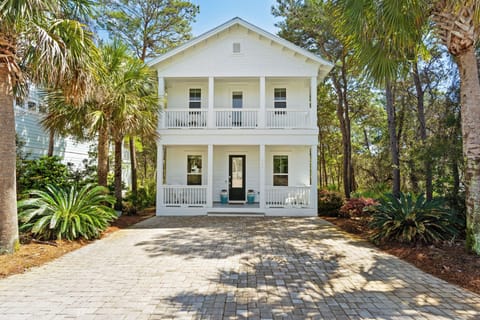 Classic Southern-style home surrounded by lush greenery.
