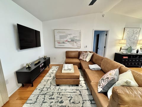 Living Room with Large Flatscreen TV and Cozy PIt Couch. Glass Doors to the Lanai.