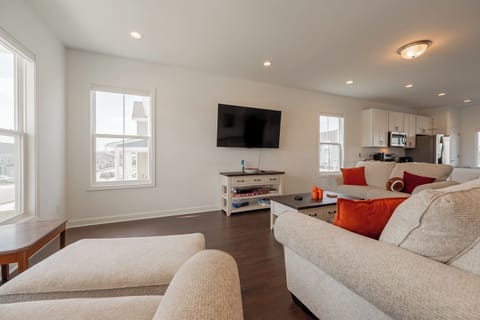Spacious living room with natural light, smart TV, and plush couches for movie nights.