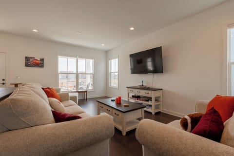 Entertainment-ready setup with board games, large screen, and comfy seating.
