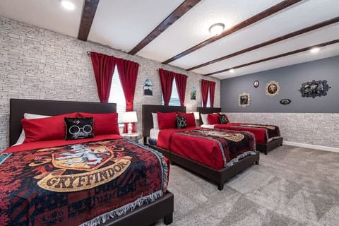 Gryffindor-themed bedroom with three cozy beds, bold decor, and wizard vibes!