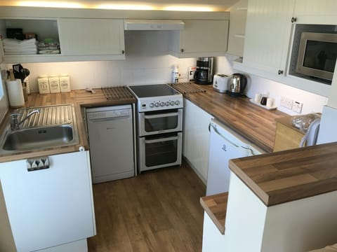 Kitchen with sink, cooker, fridge, dishwasher, kettle, toaster, microwave and coffee maker