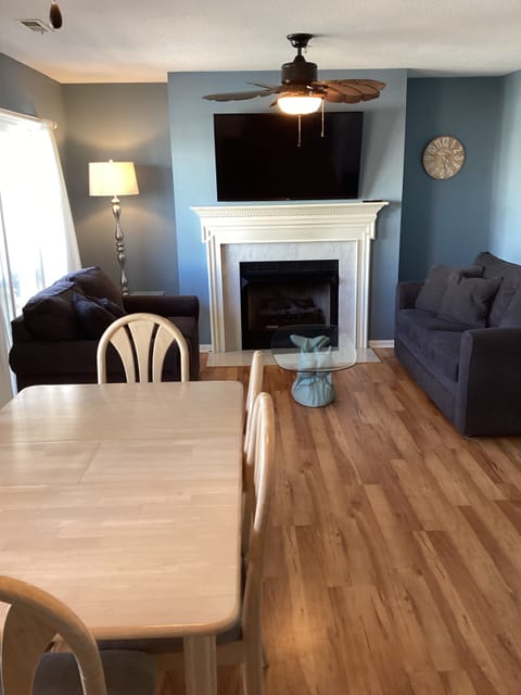 Dining table for 6 and comfy couches in living area with gas fireplace and TV