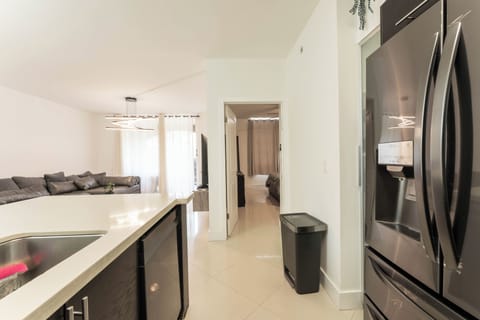 Open kitchen view with breakfast island, living room, and bedroom access